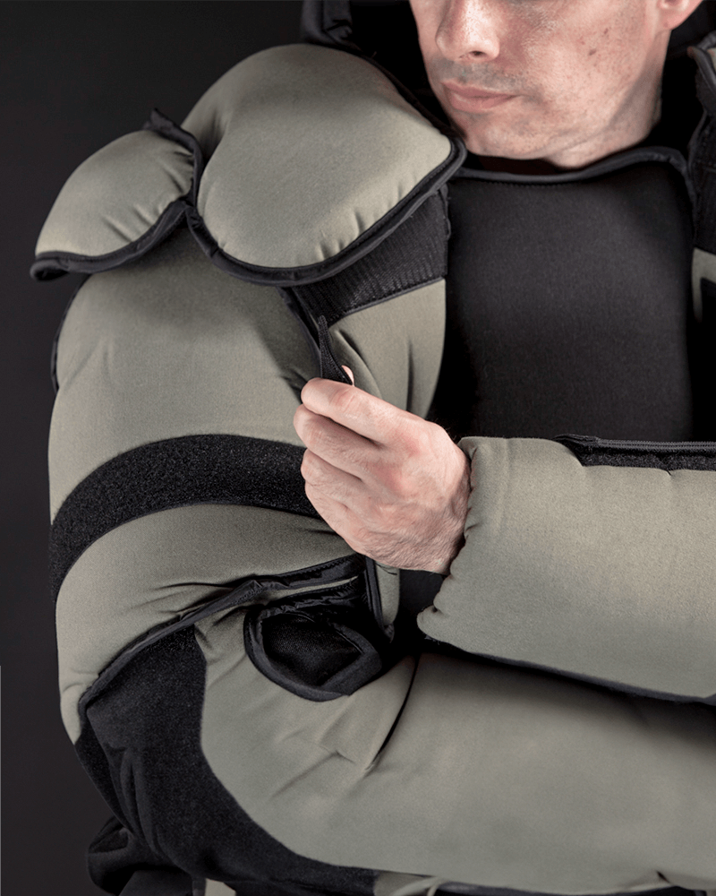 Close-up of the Mawashi T-RED training suit shoulder and arm padding with adjustable hook-and-loop closures.