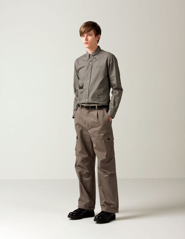 Male model in a taupe-grey Man of Moods shirt with utility graphics and matching cargo trousers.