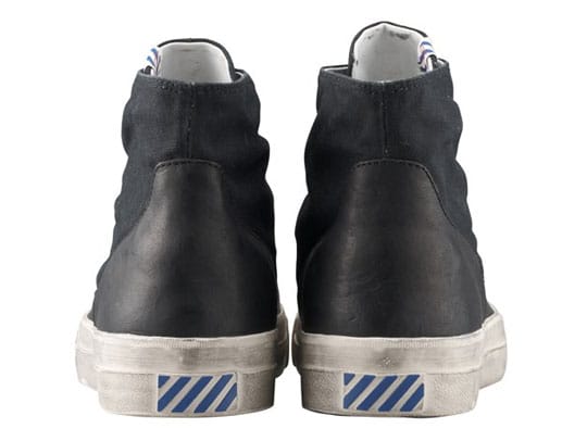 Rear view of black visvim SKAGWAY ESTLIN sneakers with blue-striped heel tabs.