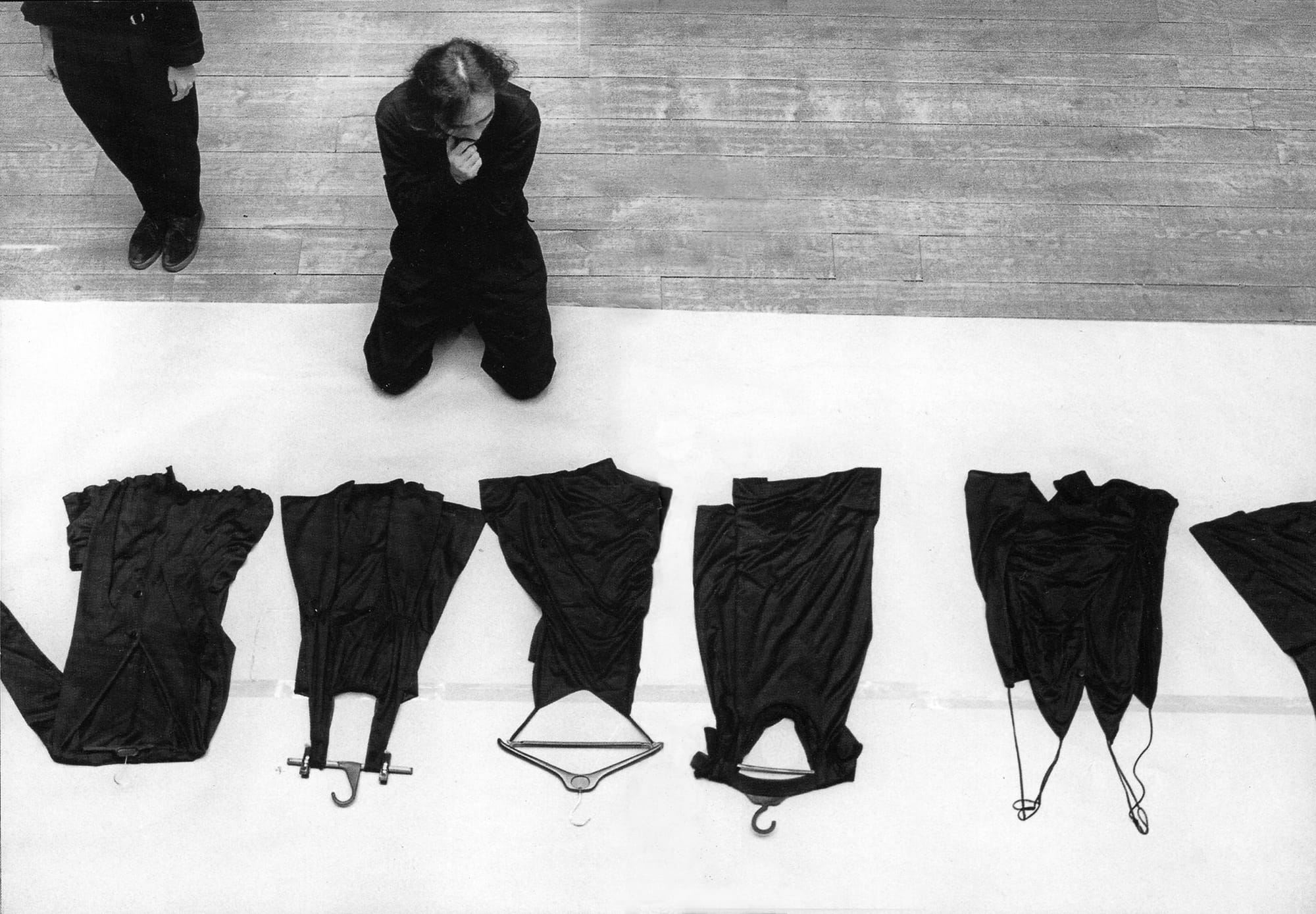 Yohji Yamamoto kneeling before black garments while making final revisions for the Spring/Summer 1991 show in Paris.