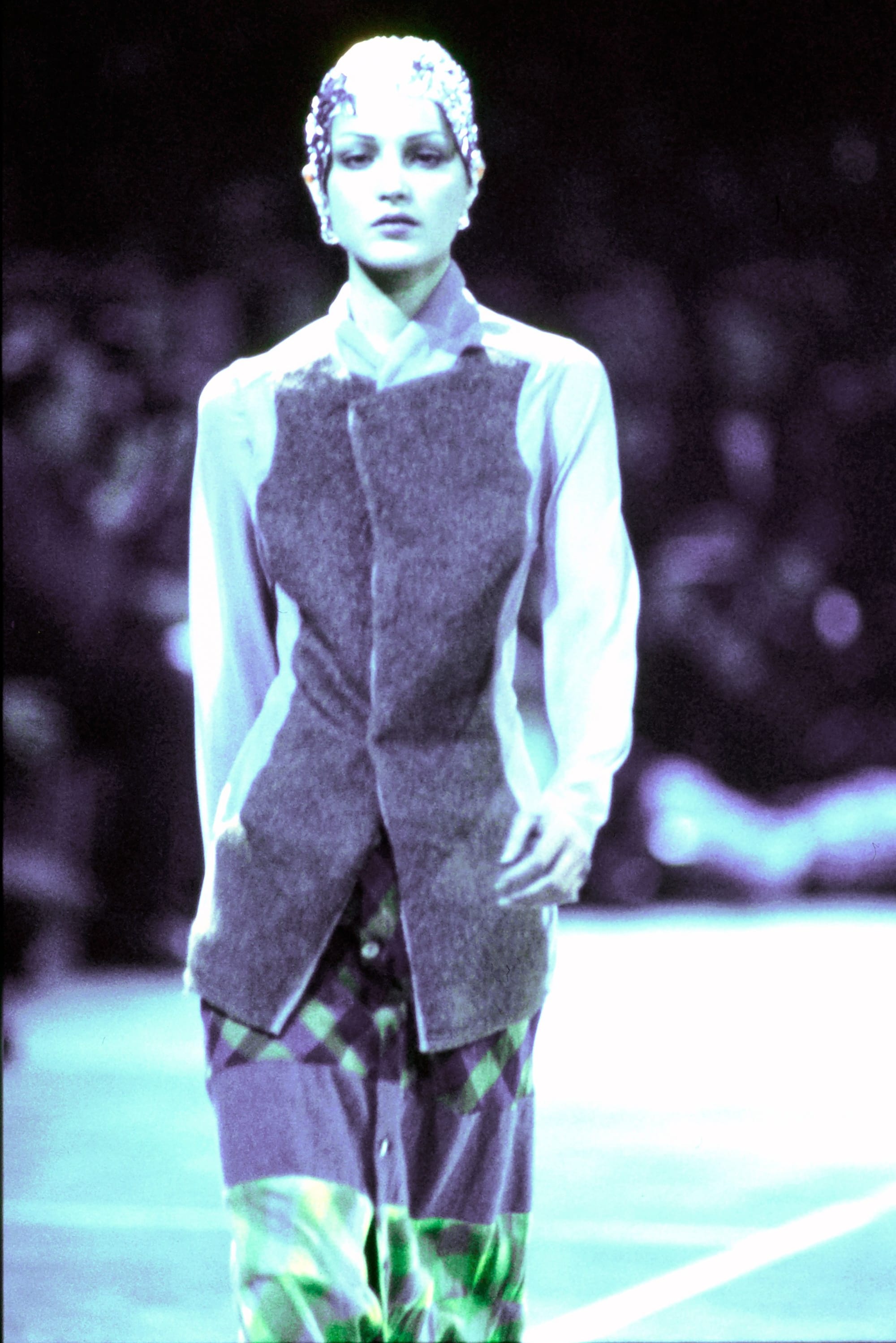 Comme des Garçons Fall 1993 Ready-to-Wear runway look 1: grey sleeveless panelled top over reflective trousers.