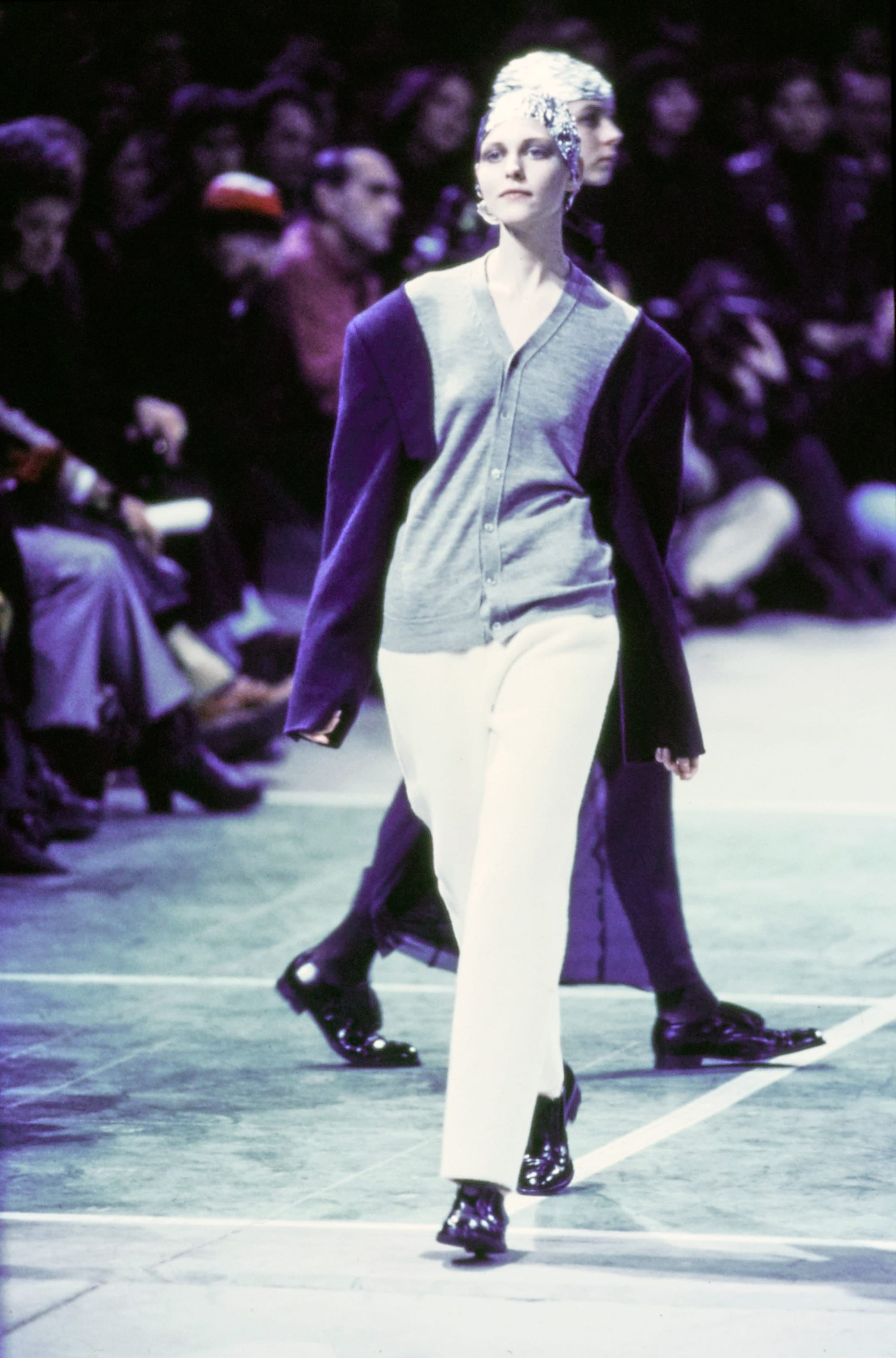 Comme des Garçons Fall 1993 Ready-to-Wear runway look 22: grey wrap jacket with pale tapered trousers.