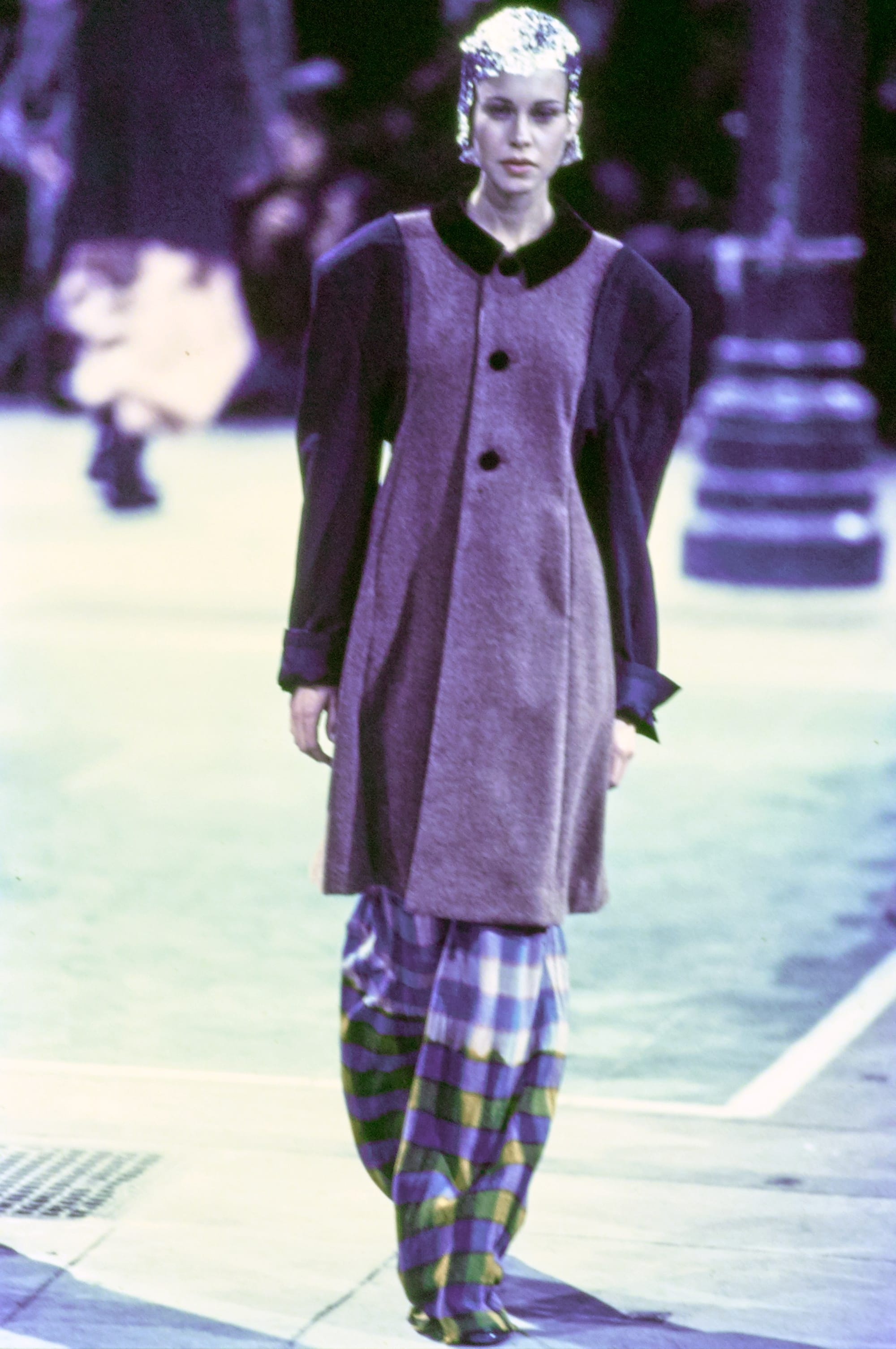 Comme des Garçons Fall 1993 Ready-to-Wear runway look 46: long purple coat over yellow-and-blue plaid trousers.