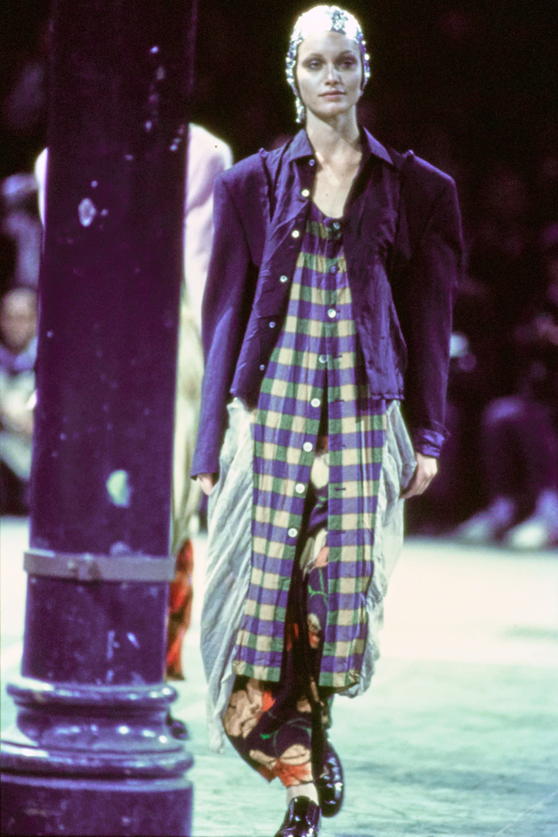 Comme des Garçons Fall 1993 Ready-to-Wear runway look 63: purple jacket over a yellow-and-blue plaid dress.