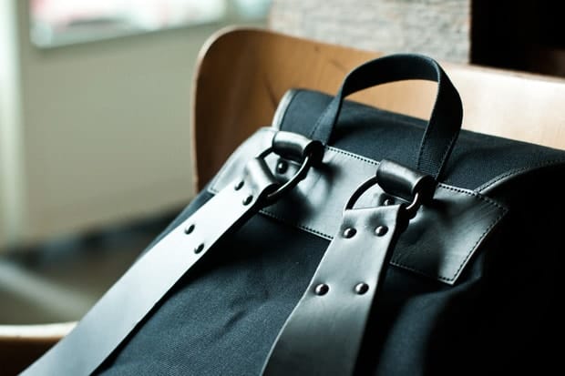 Rear carry handle and riveted leather shoulder strap attachments.