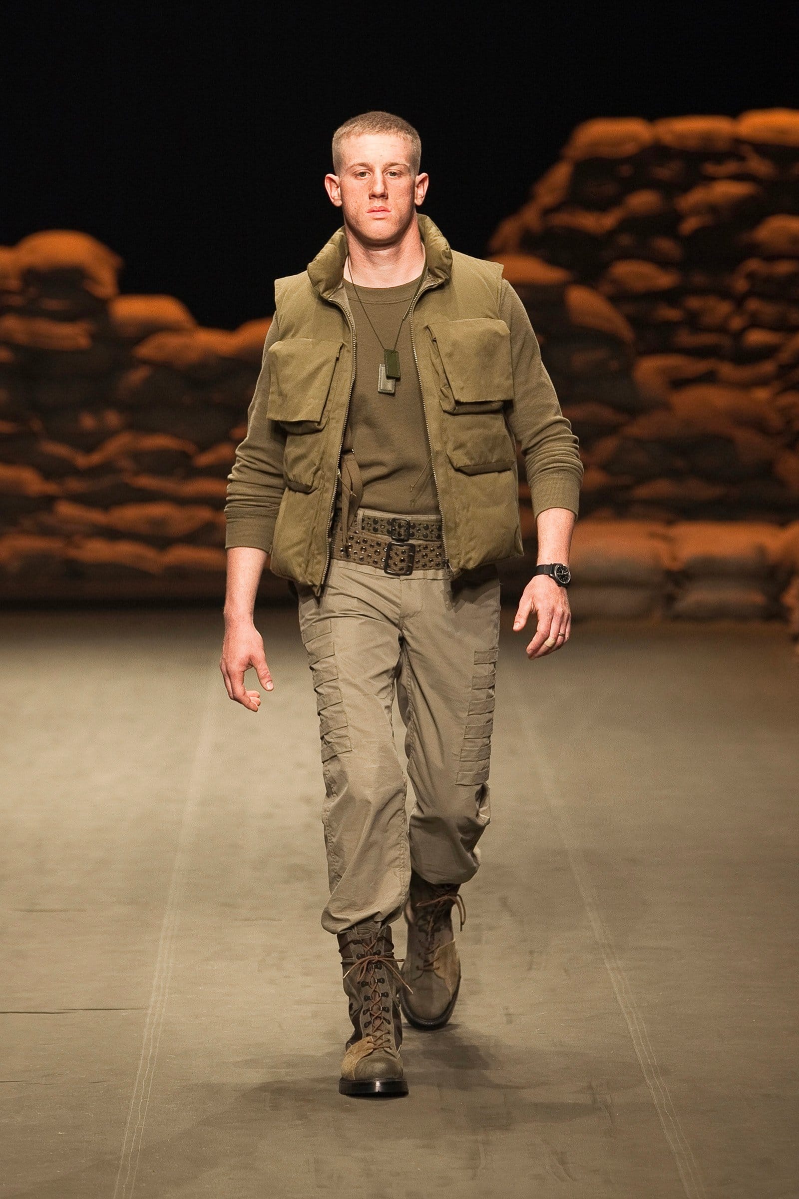 N.Hoolywood Autumn/Winter 2010–11 runway look 13: olive knit top and khaki cargo trousers with web belt and brown combat boots.