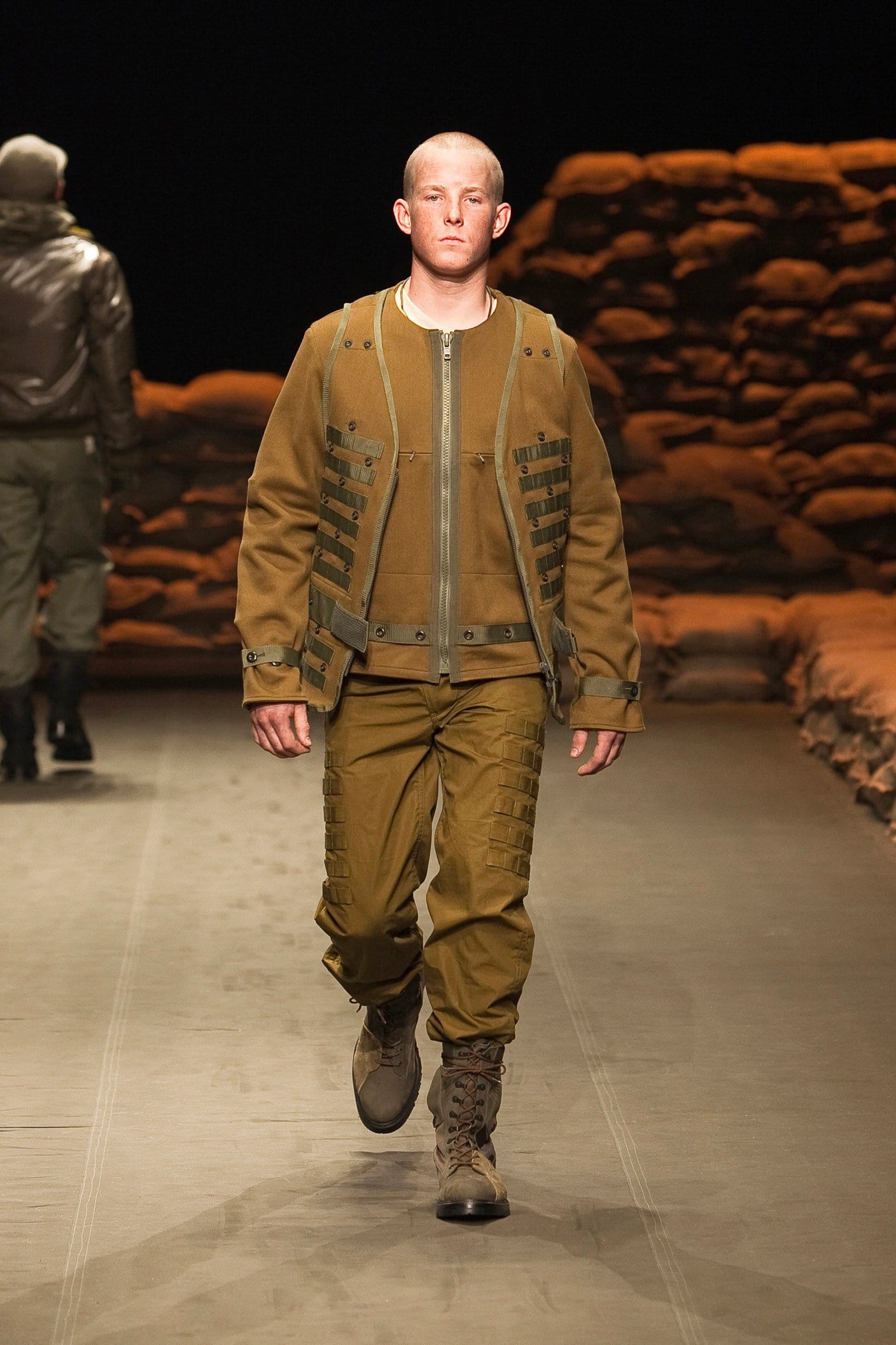 N.Hoolywood Autumn/Winter 2010–11 runway look 20: mustard bomber jacket with matching cargo trousers and brown boots.