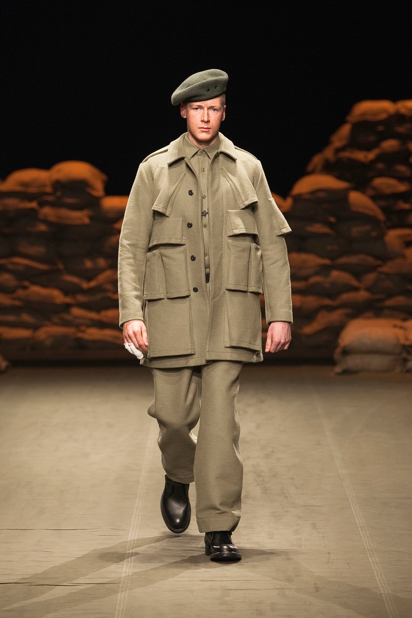 N.Hoolywood Autumn/Winter 2010–11 runway look 23: pale khaki multi-pocket field coat with matching trousers and beret.