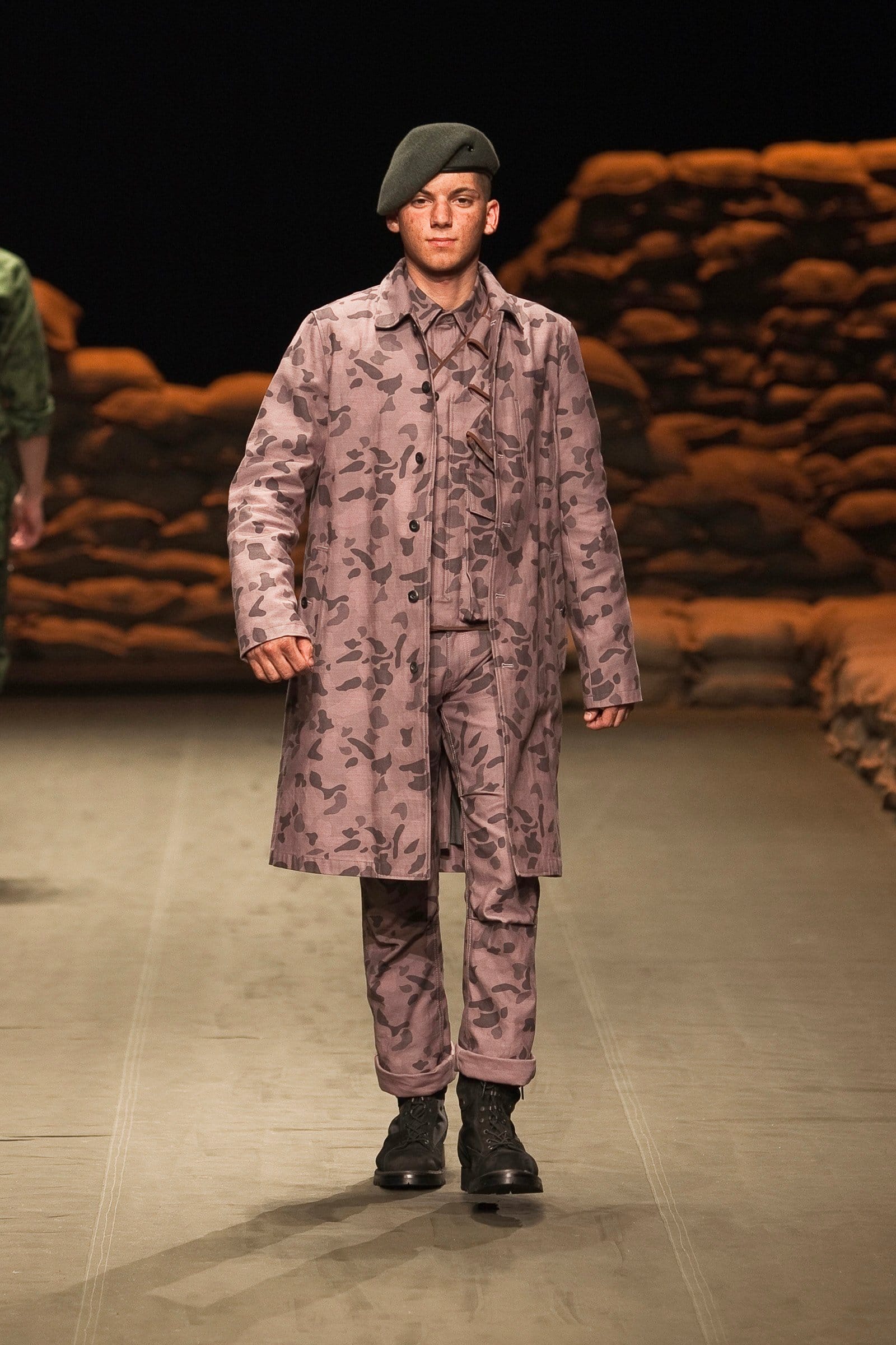 N.Hoolywood Autumn/Winter 2010–11 runway look 31: dusty pink camouflage long coat and cropped trousers with black beret.