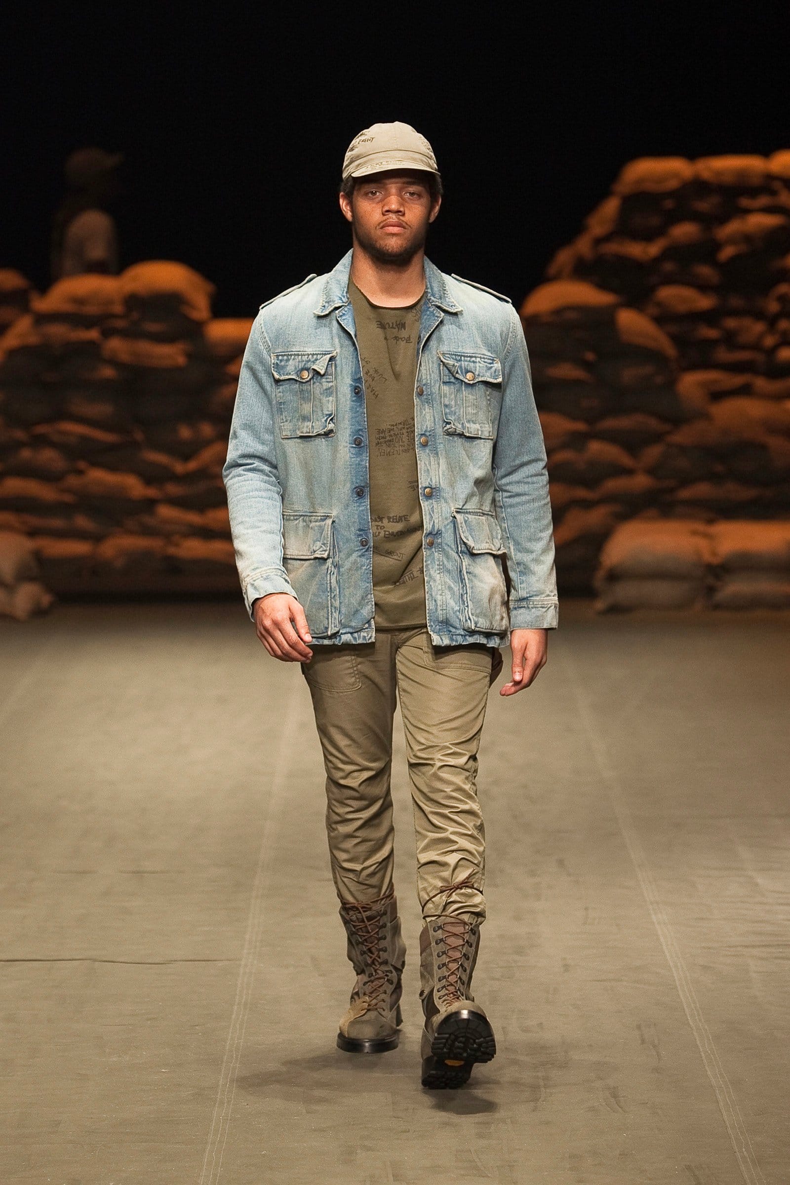 N.Hoolywood Autumn/Winter 2010–11 runway look 35: faded denim jacket over olive layers with khaki trousers and cap.