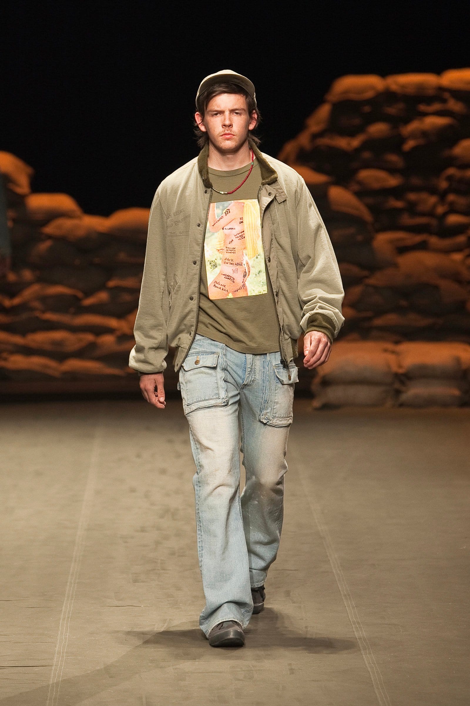 N.Hoolywood Autumn/Winter 2010–11 runway look 36: olive bomber over a printed T-shirt with faded bootcut jeans.