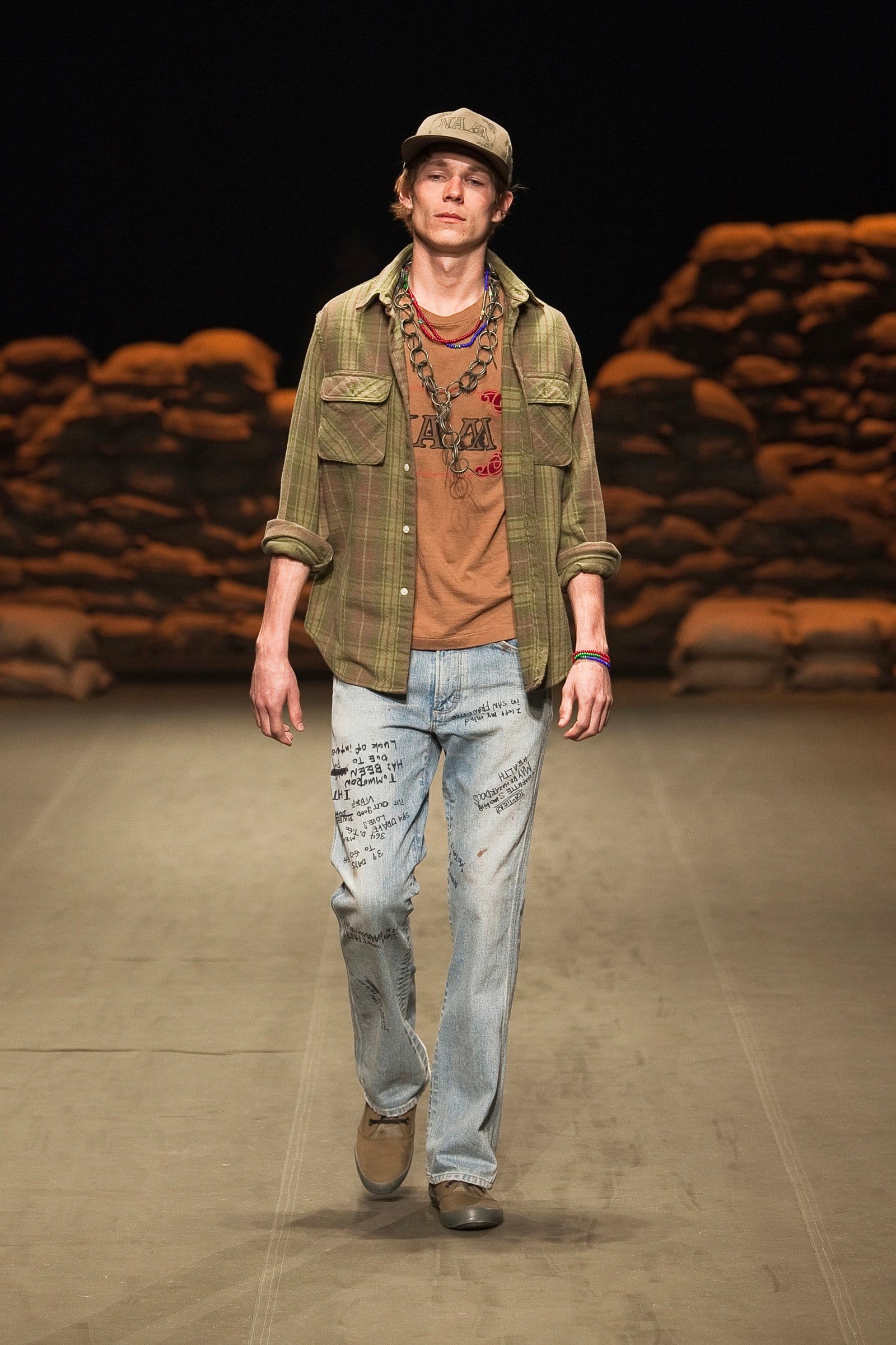 N.Hoolywood Autumn/Winter 2010–11 runway look 38: olive field jacket and printed T-shirt with distressed faded jeans.