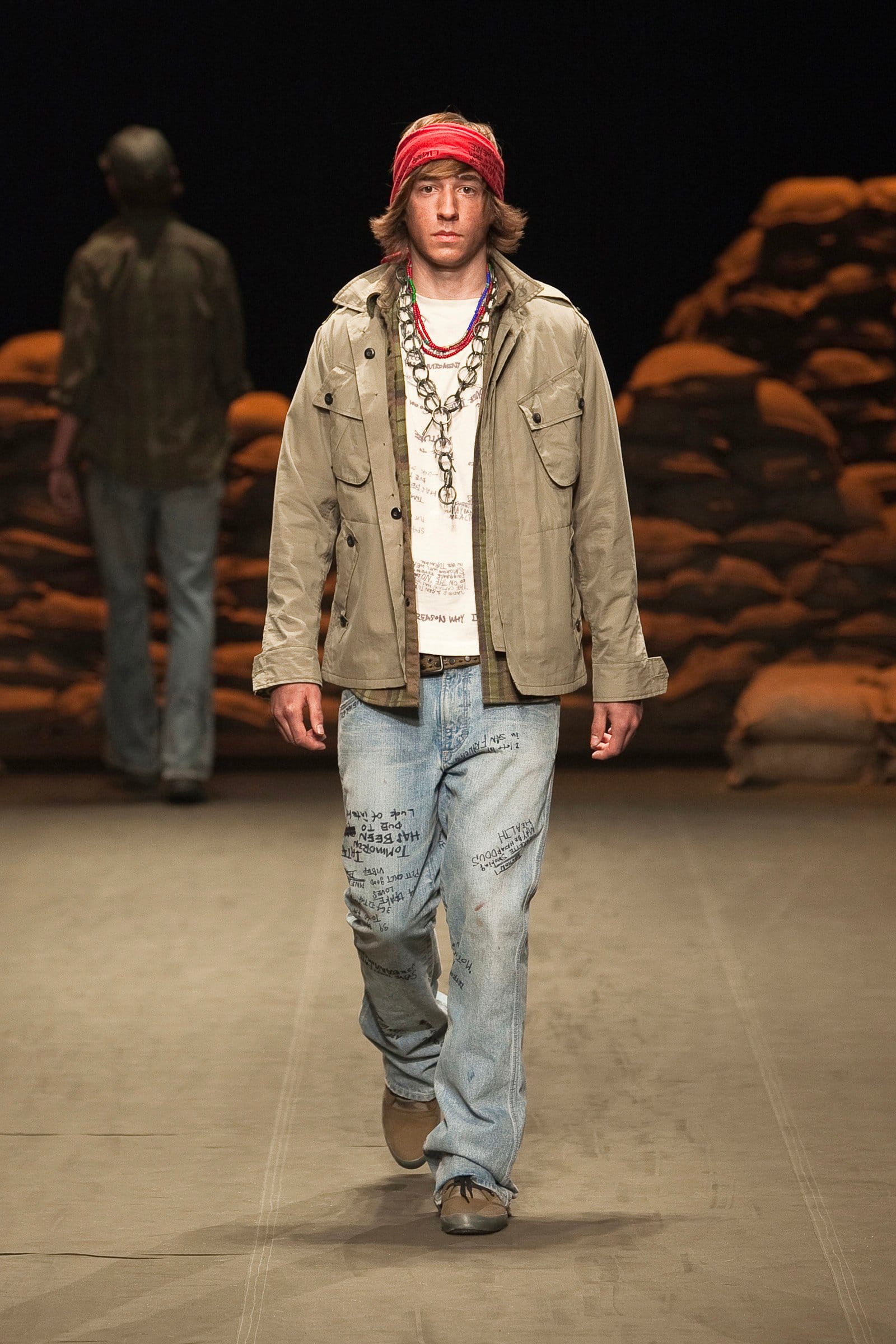 N.Hoolywood Autumn/Winter 2010–11 runway look 39: khaki field jacket and printed T-shirt with distressed jeans and red headscarf.
