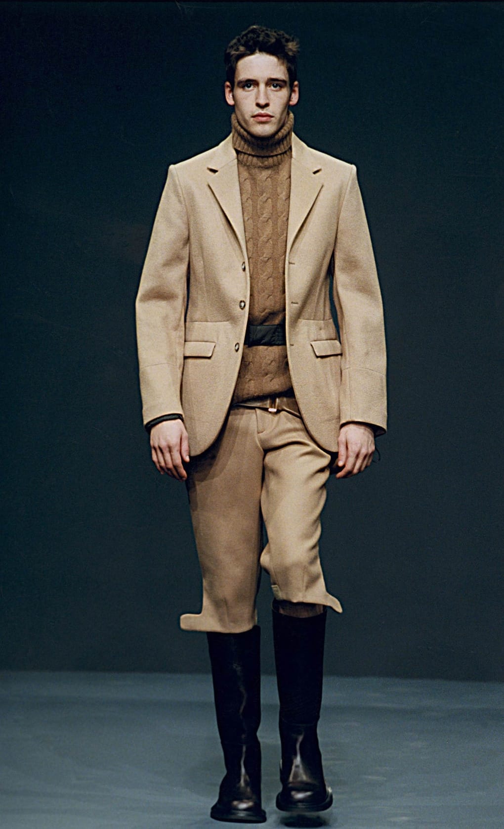 Prada Fall/Winter 1999 menswear runway look 14: camel blazer and shorts over a brown cable-knit sweater.