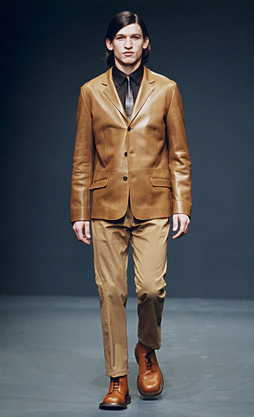 Prada Fall/Winter 1999 menswear runway look 15: brown leather blazer with tan cropped trousers and orange-brown boots.