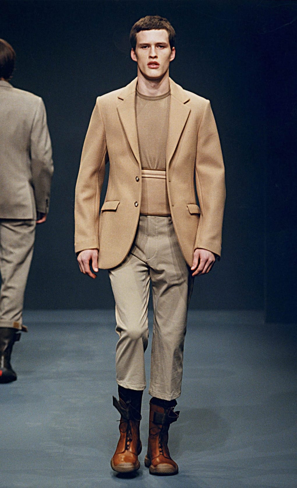 Prada Fall/Winter 1999 menswear runway look 18: camel belted blazer with cropped trousers and orange-brown boots.