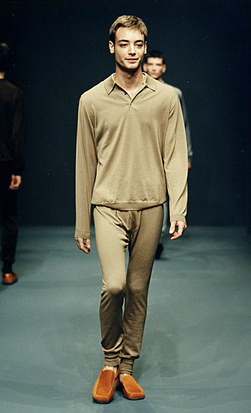 Prada Fall/Winter 1999 menswear runway look 24: khaki collared top and matching trousers with orange-brown shoes.