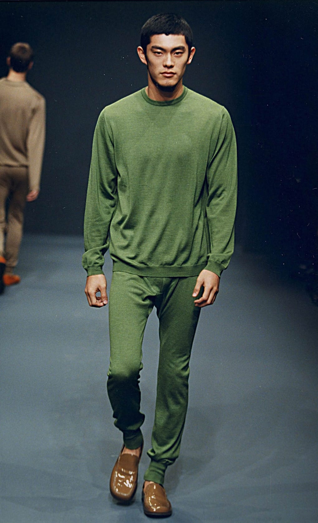 Prada Fall/Winter 1999 menswear runway look 26: green crewneck top and matching trousers with tan shoes.
