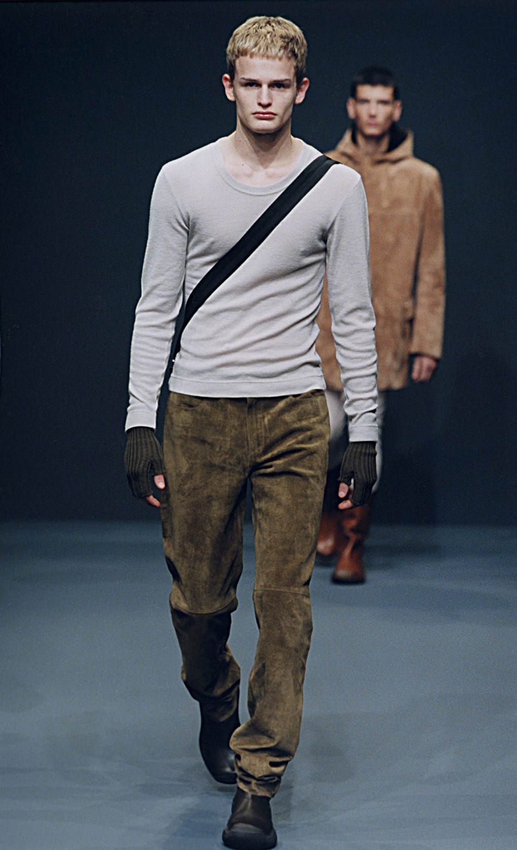 Prada Fall/Winter 1999 menswear runway look 3: grey long-sleeve top with olive trousers, gloves, and crossbody strap.