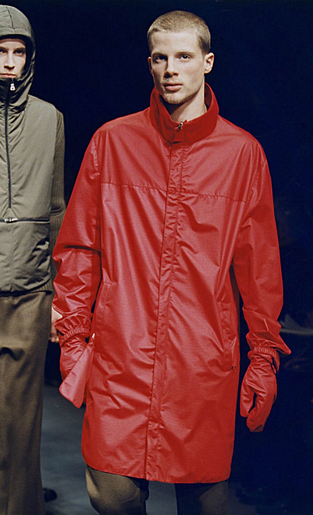 Prada Fall/Winter 1999 menswear runway look 40: bright red technical coat with matching gloves and brown trousers.