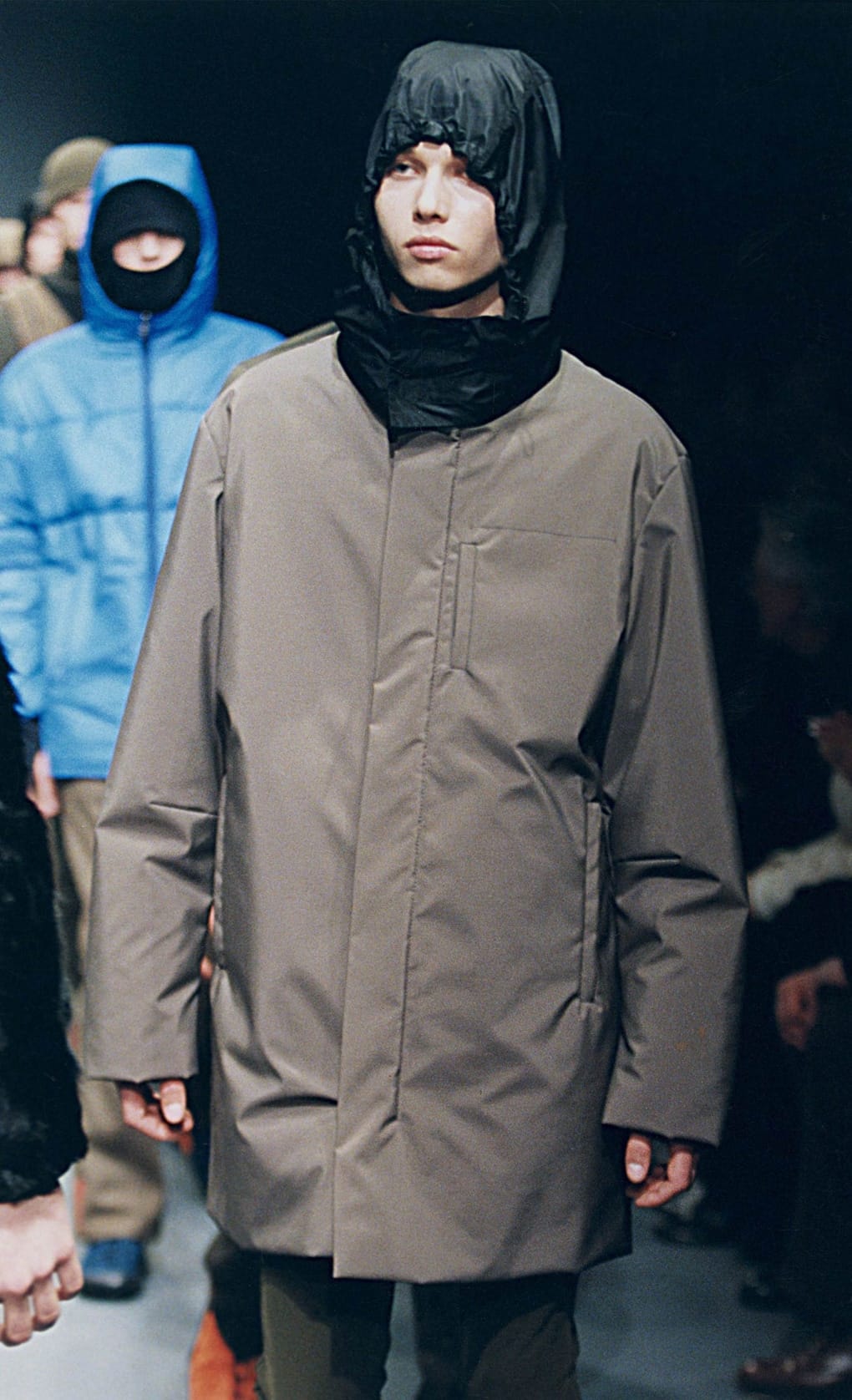 Prada Fall/Winter 1999 menswear runway look 48: taupe hooded technical coat with dark trousers.