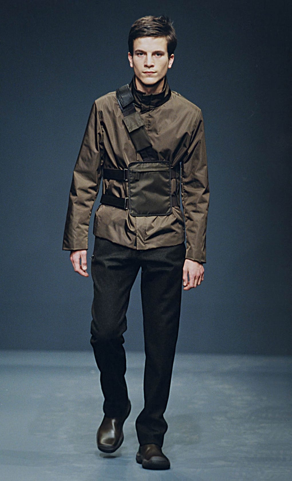 Prada Fall/Winter 1999 menswear runway look 59: brown belted field jacket with dark trousers and boots.