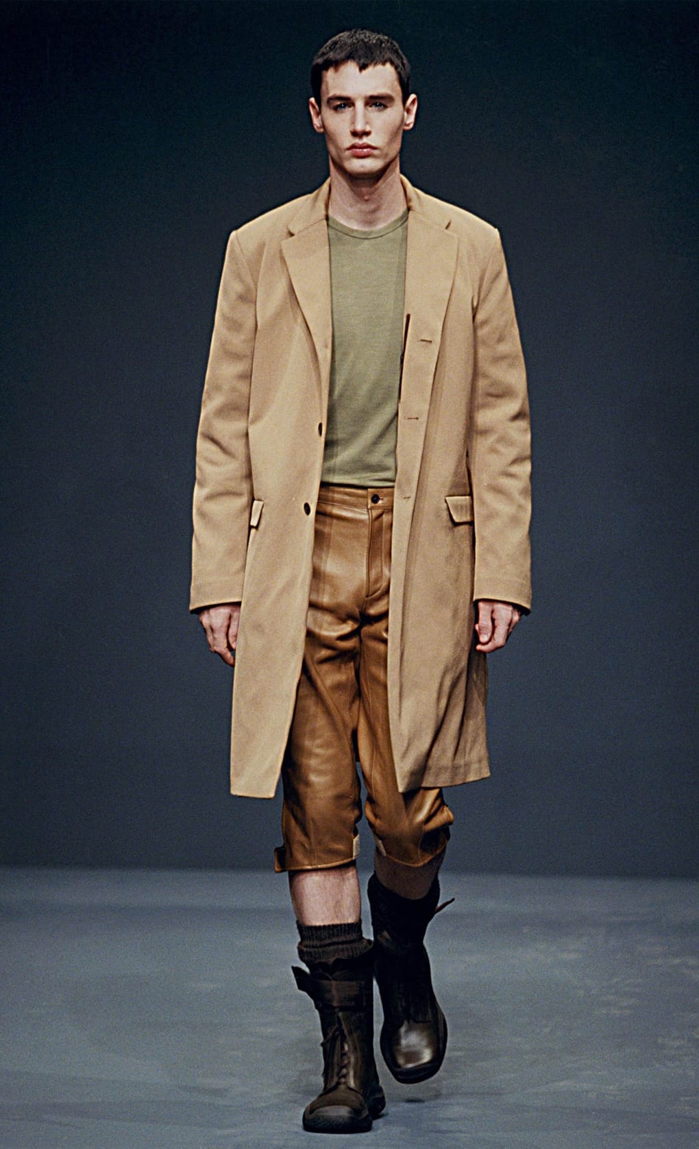 Prada Fall/Winter 1999 menswear runway look 65: camel long blazer with brown cropped trousers and tall boots.