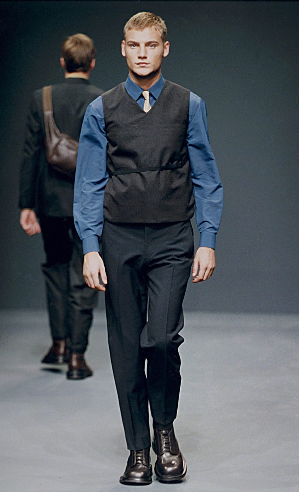 Prada Fall/Winter 1999 menswear runway look 73: black vest over a blue shirt with dark cropped trousers.