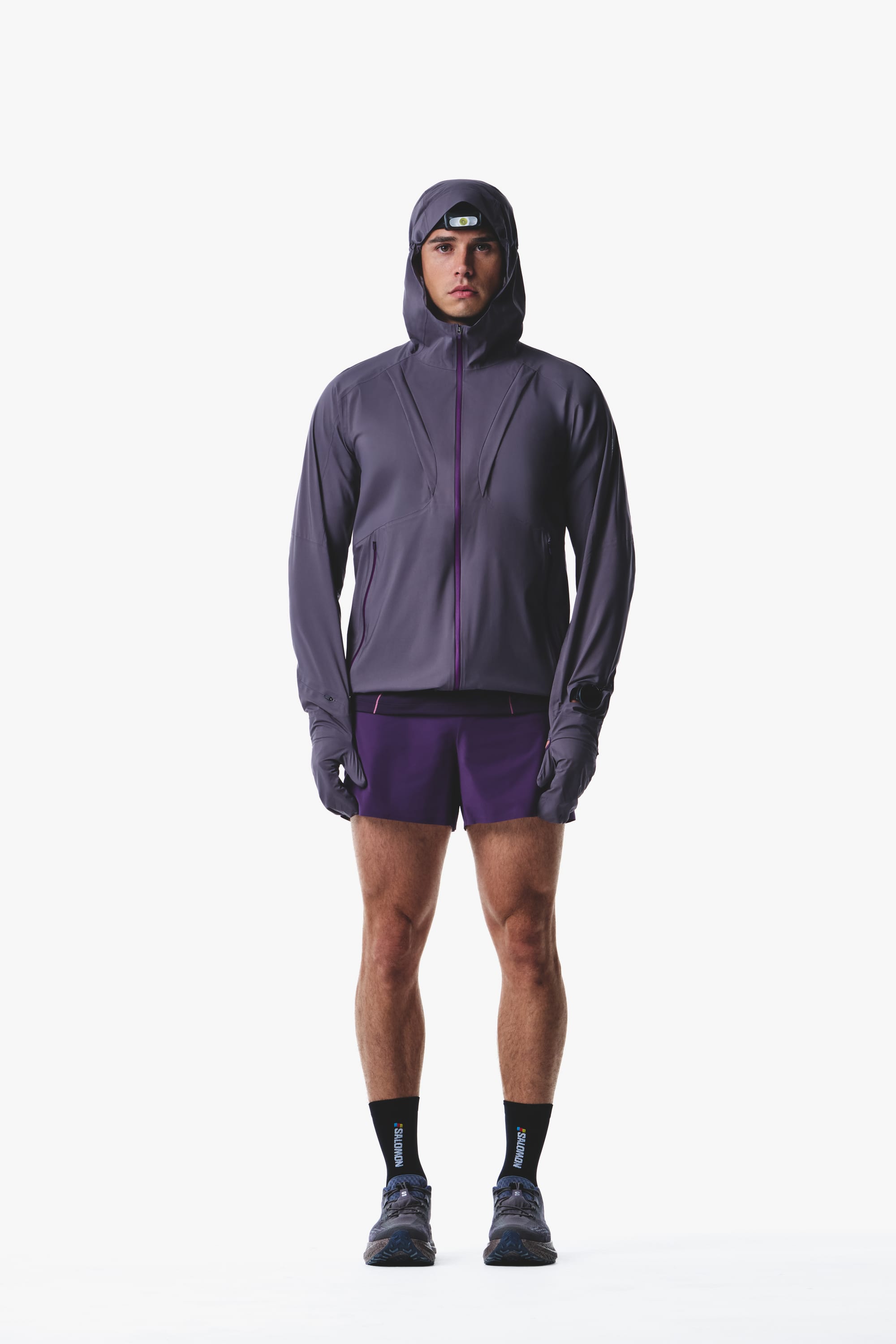 Salomon men's Autumn/Winter 2026 purple hooded trail-running jacket and shorts, front view.