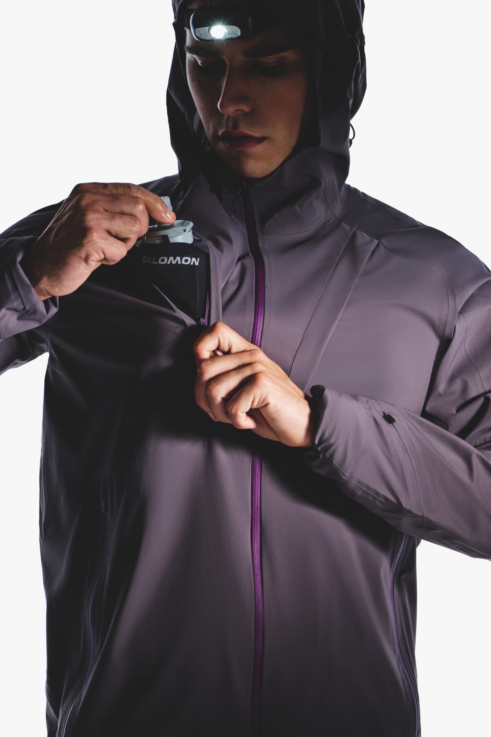 Close-up of the Salomon men's Autumn/Winter 2026 purple hooded jacket and chest pocket zipper.