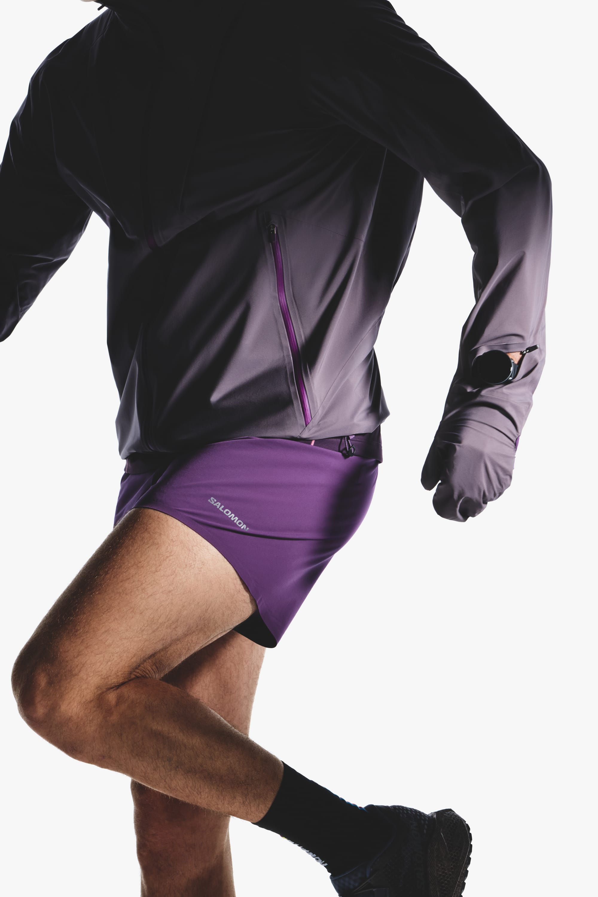 Running detail of the Salomon men's Autumn/Winter 2026 purple hooded jacket and split shorts.