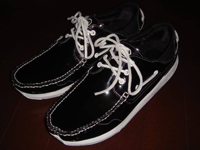 Pair of black patent-leather Visvim G.Sausalito shoes with white laces and contrast stitching, viewed from the front.