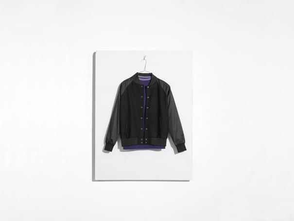 Black technical jacket photographed against a white studio background.