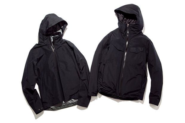 Two black hooded technical jackets shown on a white studio background.