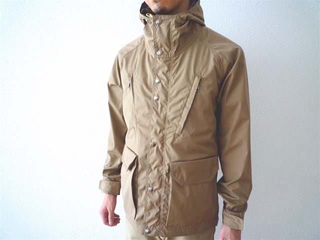 Tan high-collar technical jacket worn by a model.