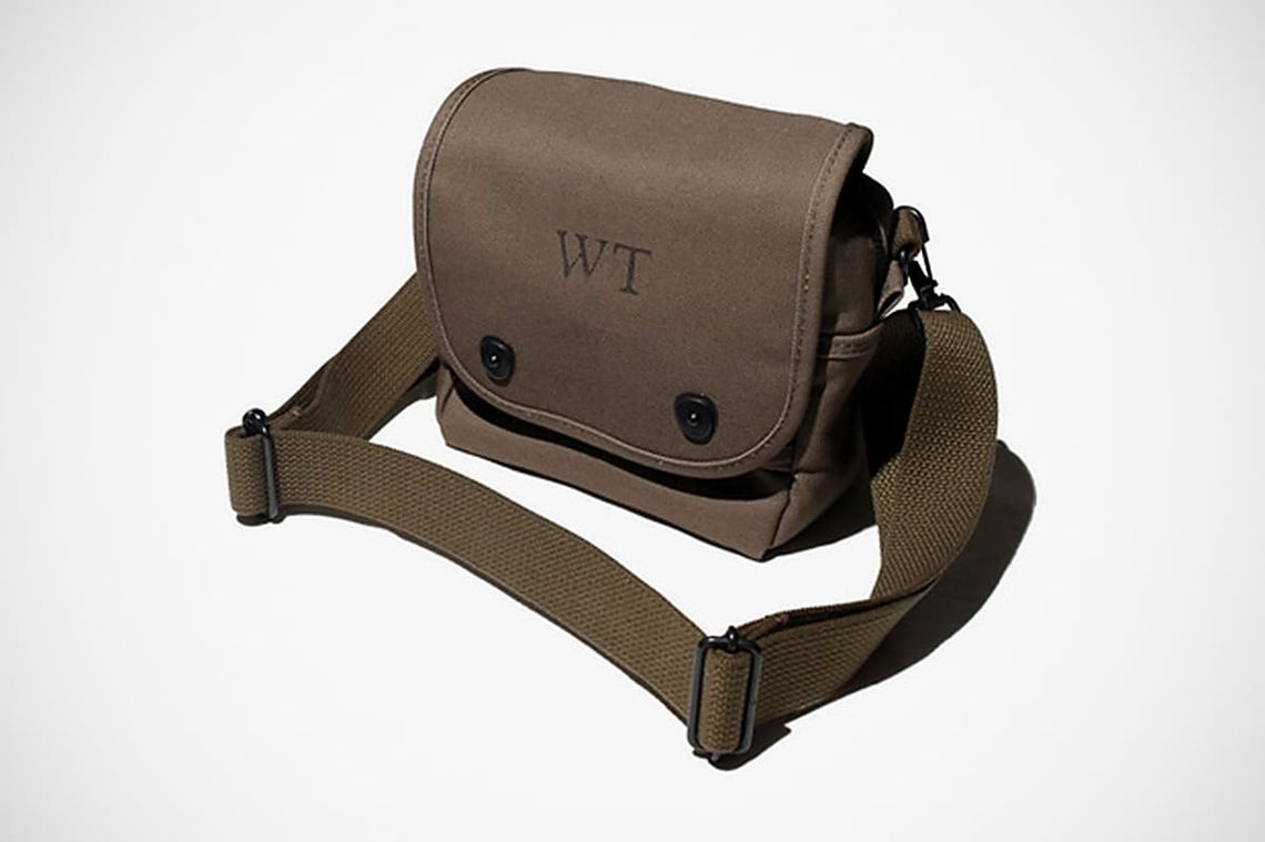 WTAPS khaki shoulder bag with flap closure and adjustable webbing strap.