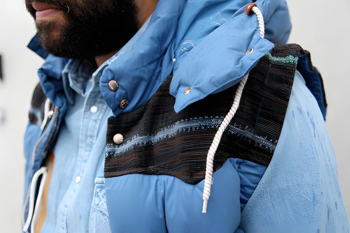 Moncler V × Visvim Gyantse quilted down vest from FW2011, featuring a nylon body, multicolor wool stripe yoke panels, and det