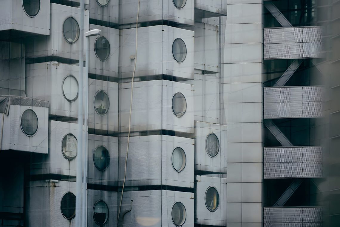 Close-up of Nakagin Capsule Tower facade, stacked steel capsule units with circular porthole windows, Tokyo 2016.