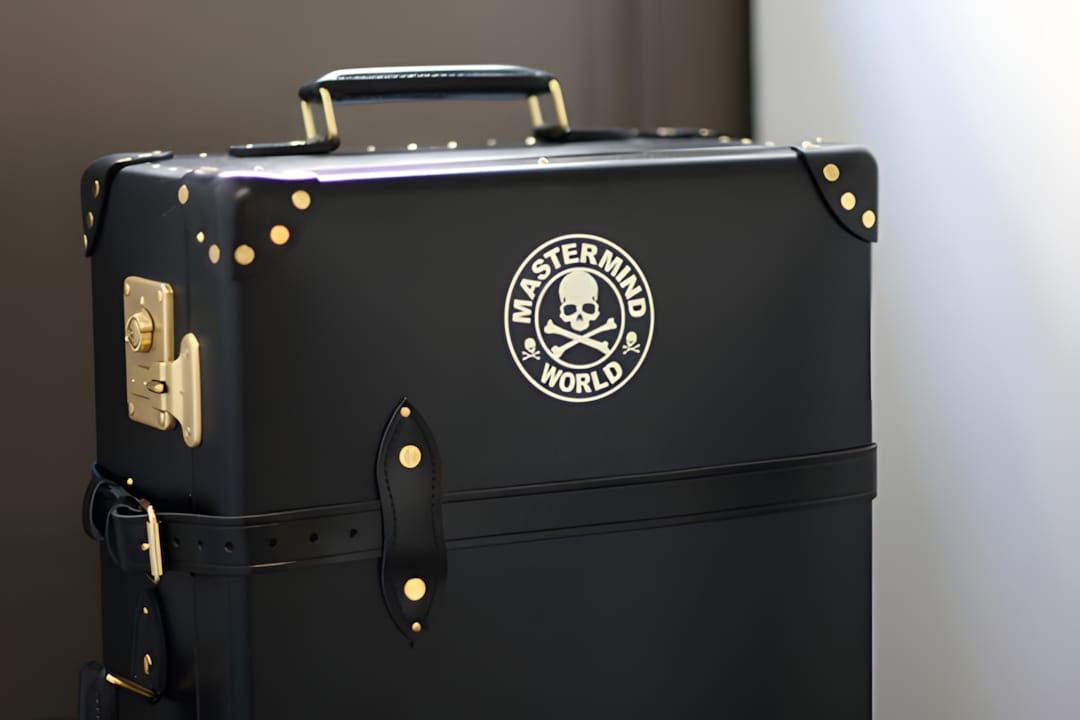 mastermind JAPAN x Globe-Trotter collaboration trunk in ink-black Vulcan Fiber with gold hardware and cross-buckling leather 