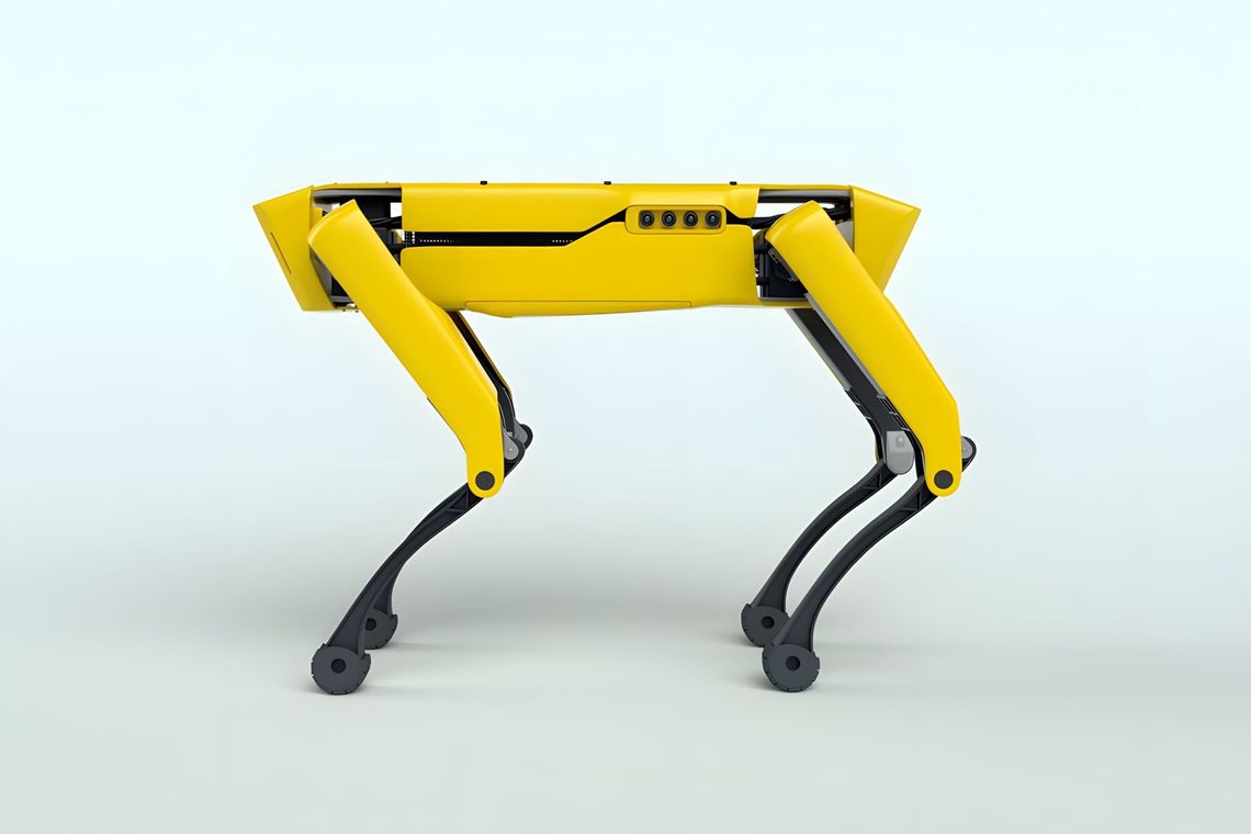 Boston Dynamics SpotMini robot, yellow and black, three-quarter rear studio shot on grey background.