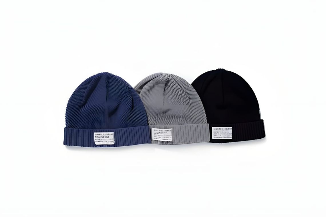 Norse Projects Cotton Watch Beanies in navy, grey, and black, each with woven label patch on folded cuff.
