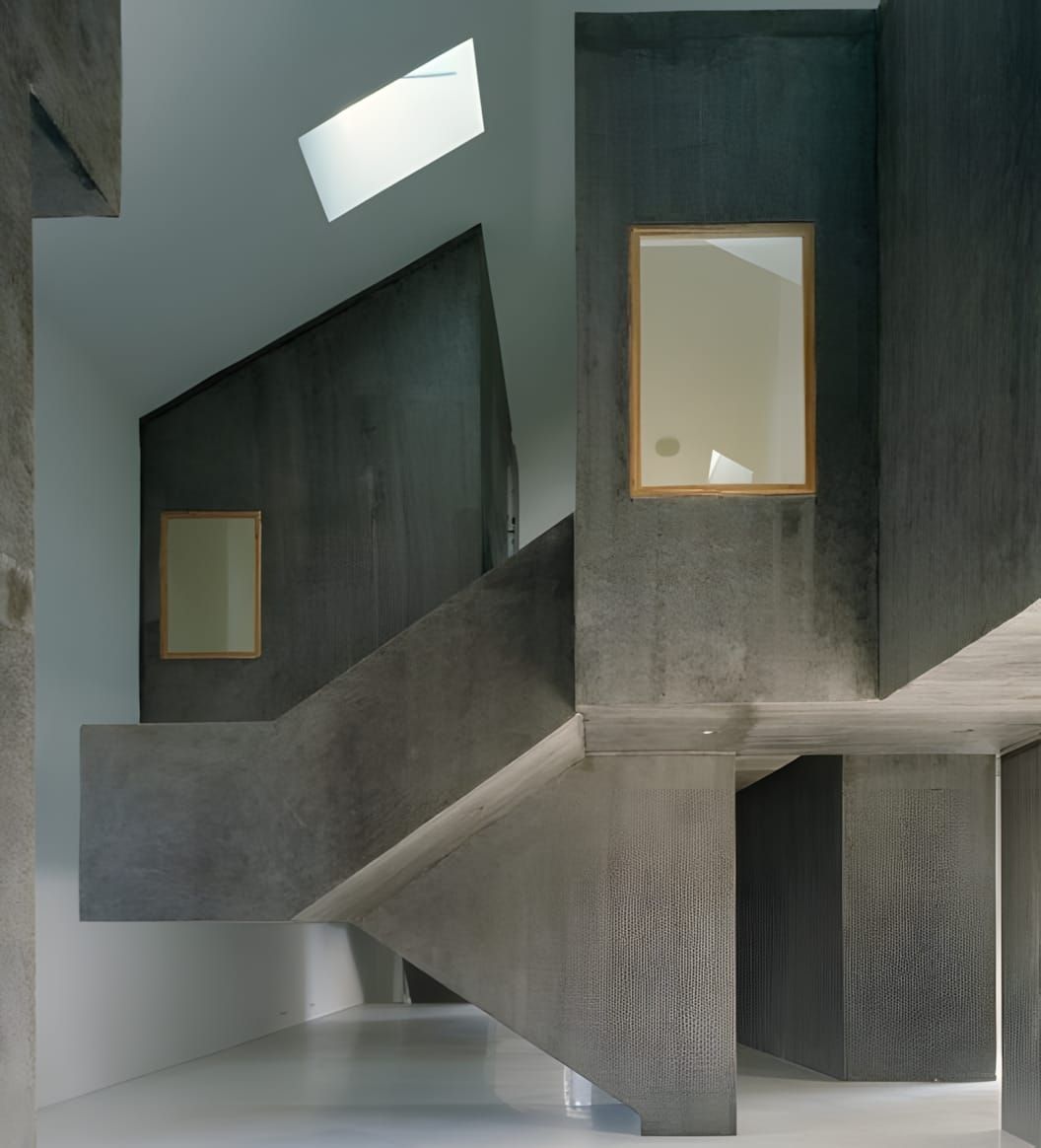 Interior concrete passage at Casa dos Cubos, Tomar — a cantilevered staircase and compressed vertical space within the reconv
