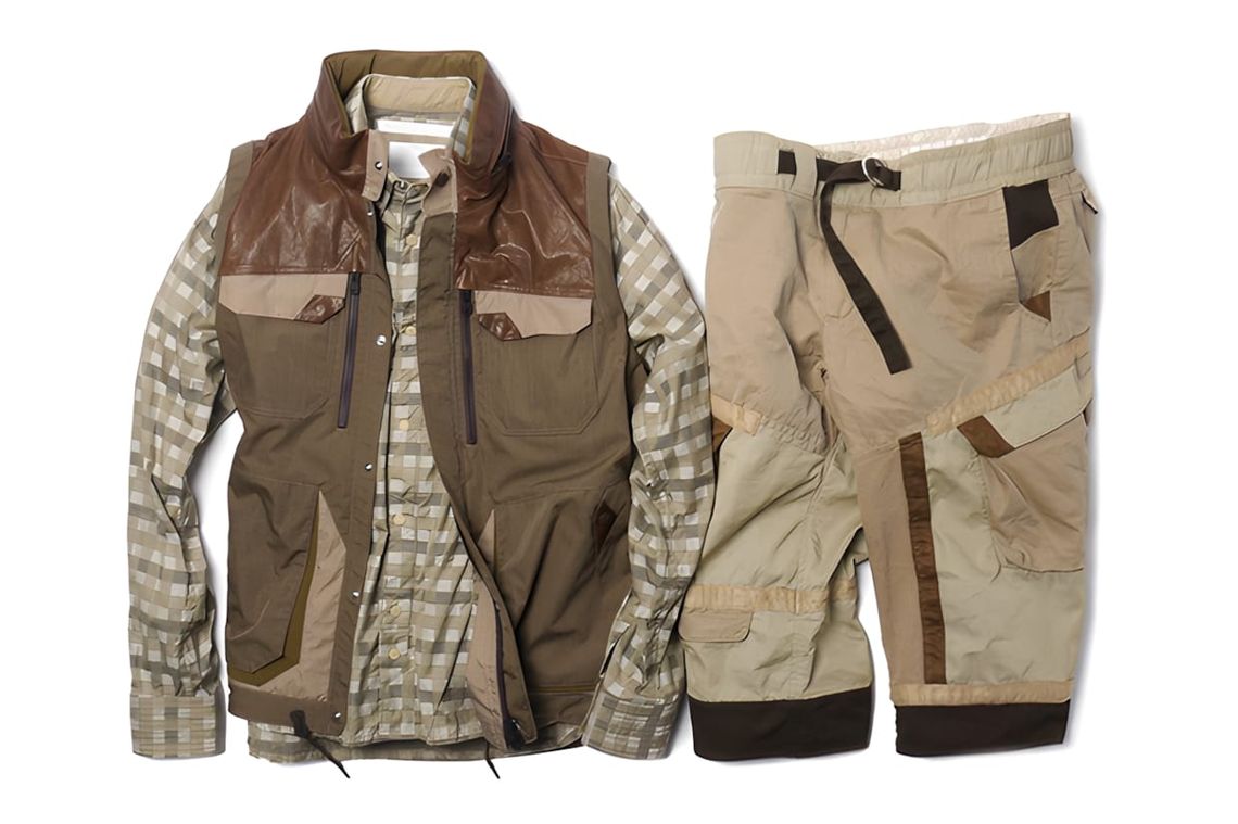 White Mountaineering Cotton Cloth Luggage Down Vest in beige — front view of a down-filled technical vest with zip chest pock