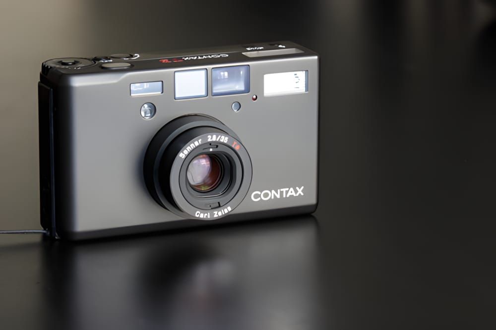 Contax T3 35mm compact film camera in titanium silver finish, front view showing Carl Zeiss Sonnar T* 35mm f/2.8 lens and CON