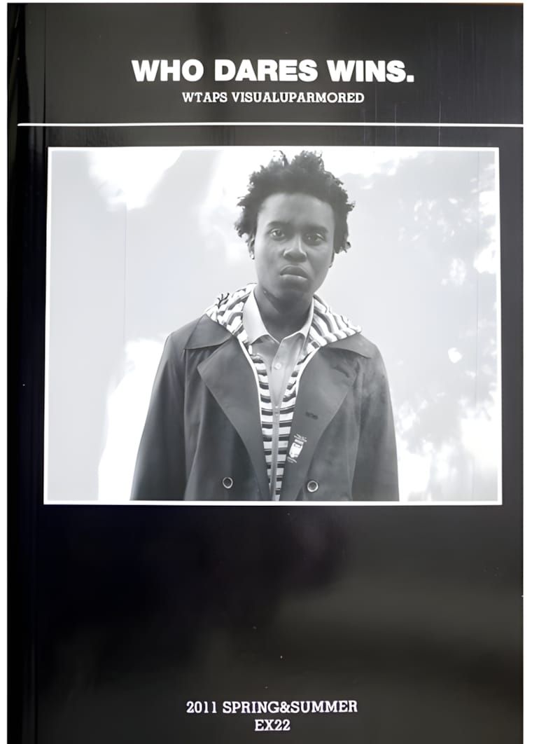 WTAPS Spring/Summer 2011 lookbook cover poster: bold white text reading 'WHO DARES WINS.' above a young Black male figure in 