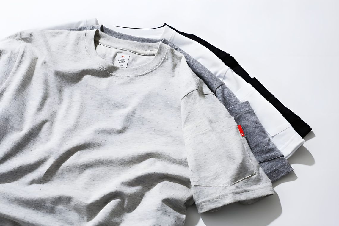 Four folded Head Porter Plus cotton crew-neck pocket t-shirts fanned out on a white surface — light grey marl in front (size 