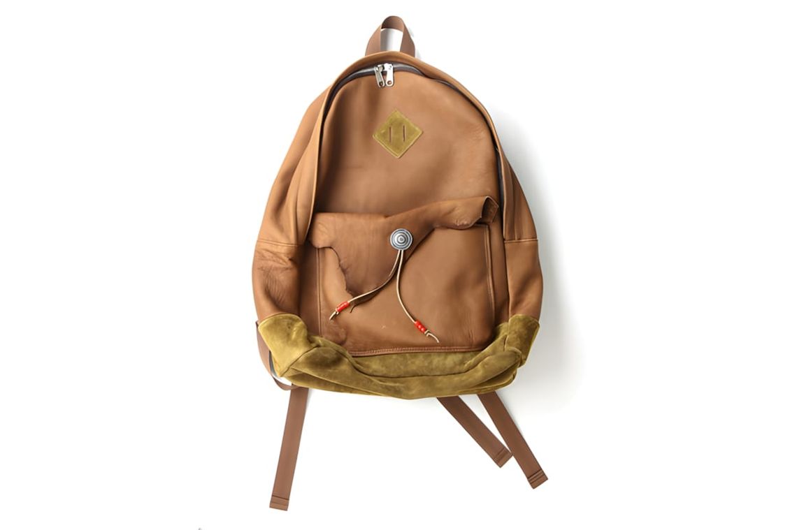 Rehacer Deer Daypack in tan deerskin leather with olive suede bottom panel, silver diamond badge on upper panel, front pocket