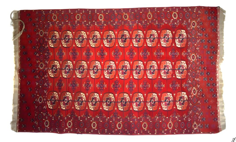 Antique Tekke Turkoman main carpet with a deep madder-red field covered in rows of quartered octagonal Tekke gul medallions a