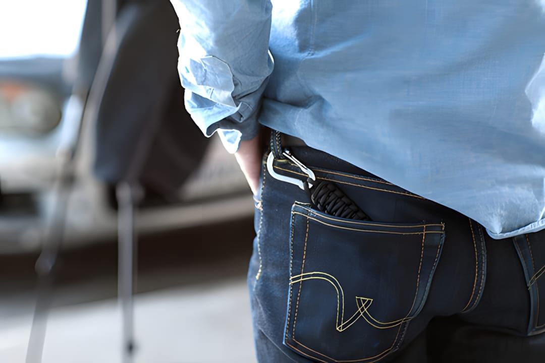 DSPTCH paracord wrist strap with stainless steel clip, shown clipped to the back pocket of raw denim jeans, March 2013.