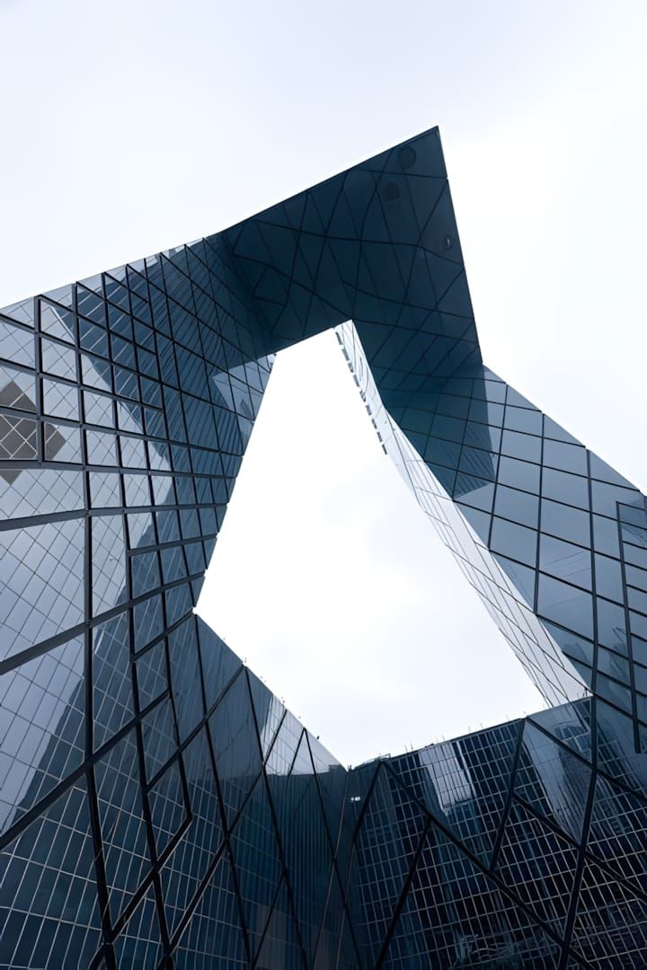 Worm's-eye view through the central void of CCTV Headquarters, Beijing — diagonal steel exoskeleton grid on both tower legs f